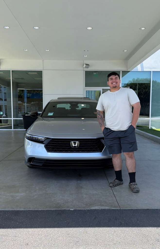Client vehicle delivery — sedan at dealership canopy